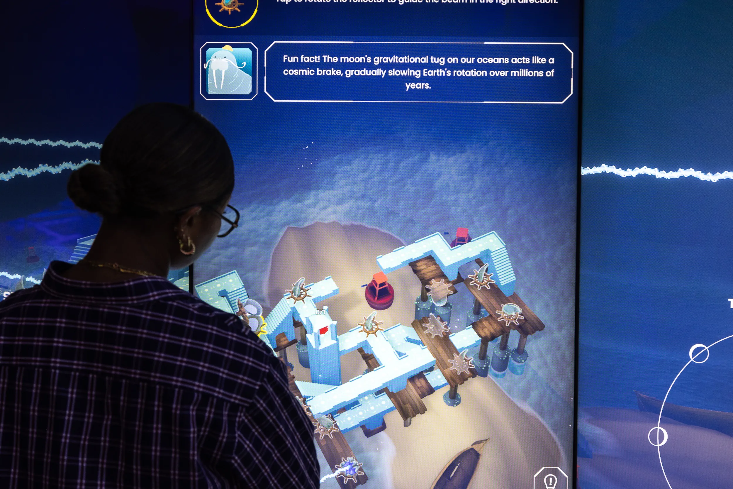 Visitor engaging with an EarthTime puzzle on a large touchscreen.