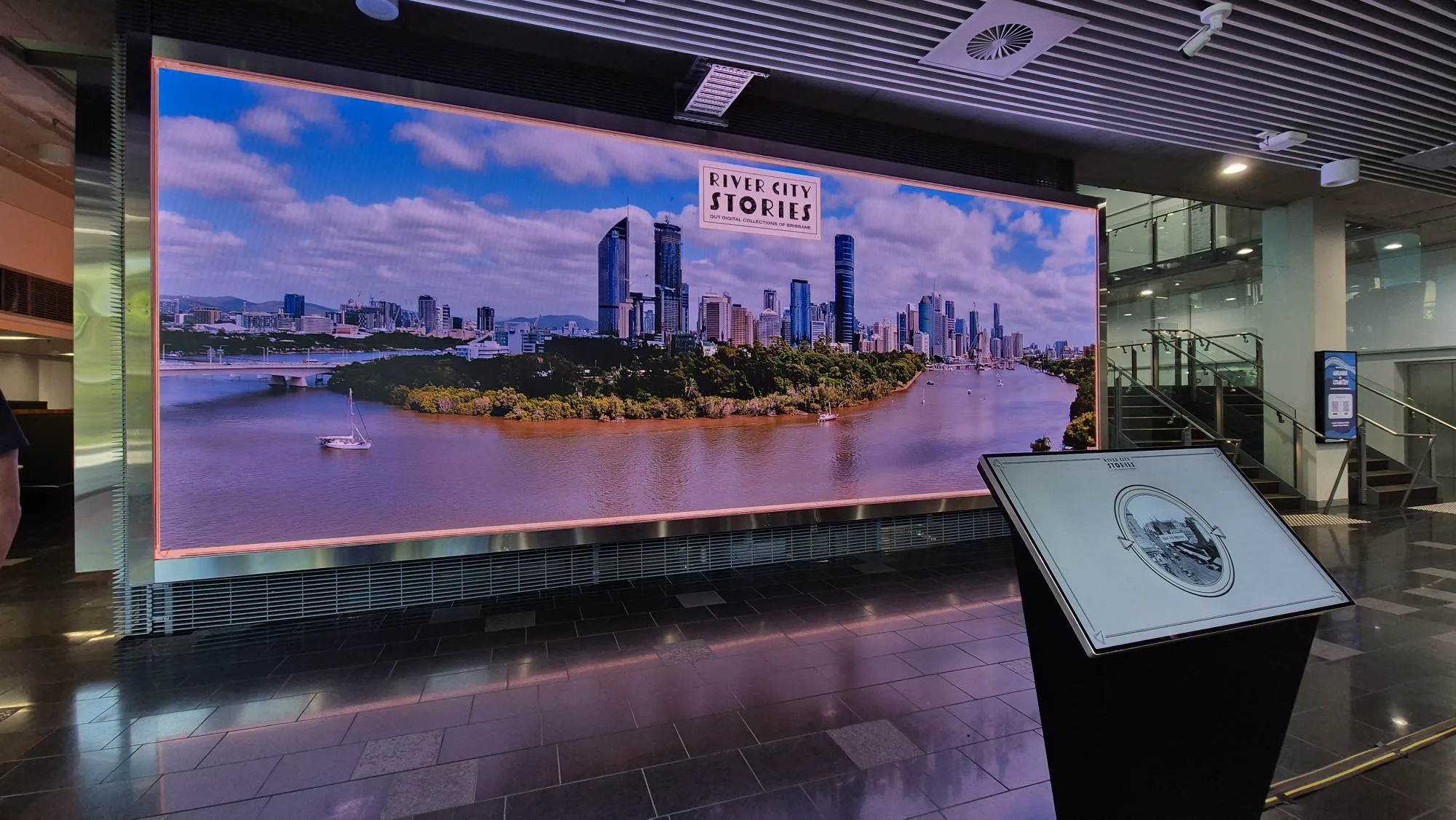 River City Stories displayed on The Cube with a kiosk screen in front of the large LED wall.
