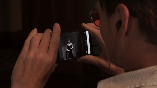 Close view of a visitor viewing a triggered AR scene on a phone.